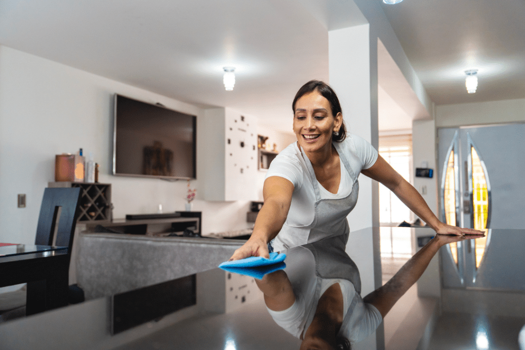 Residential cleaning professional polishing a kitchen countertop in a modern home in Lancaster, Texas.