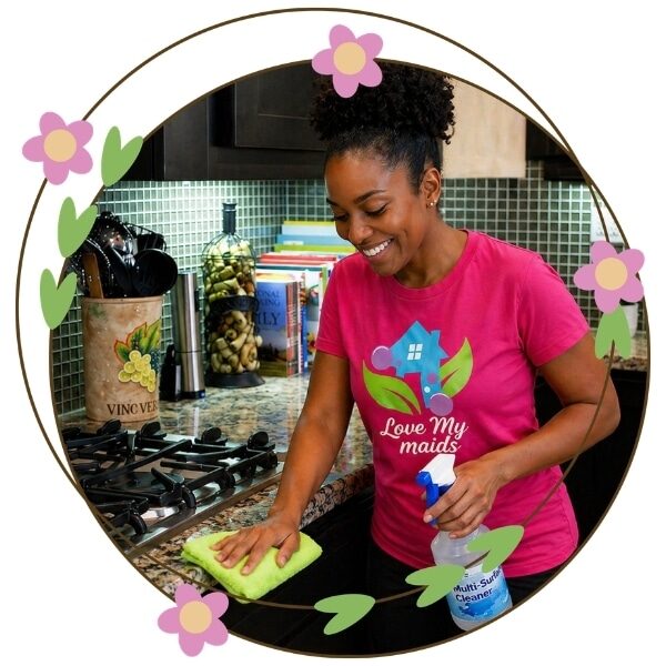 A professional hosue cleaners performing a deep cleaning in a client kitchen.