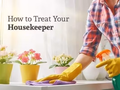 A woman cleans a white table with flower pots on it under the words "How to Treat Your Housekeeper"